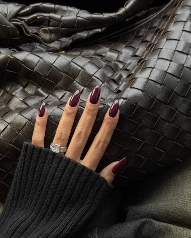 Burgundy nail polish on tan skin with a rich elegant finish.