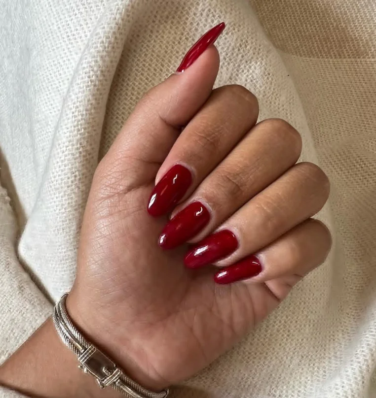 Cherry red nails styled with a purple cocktail dress