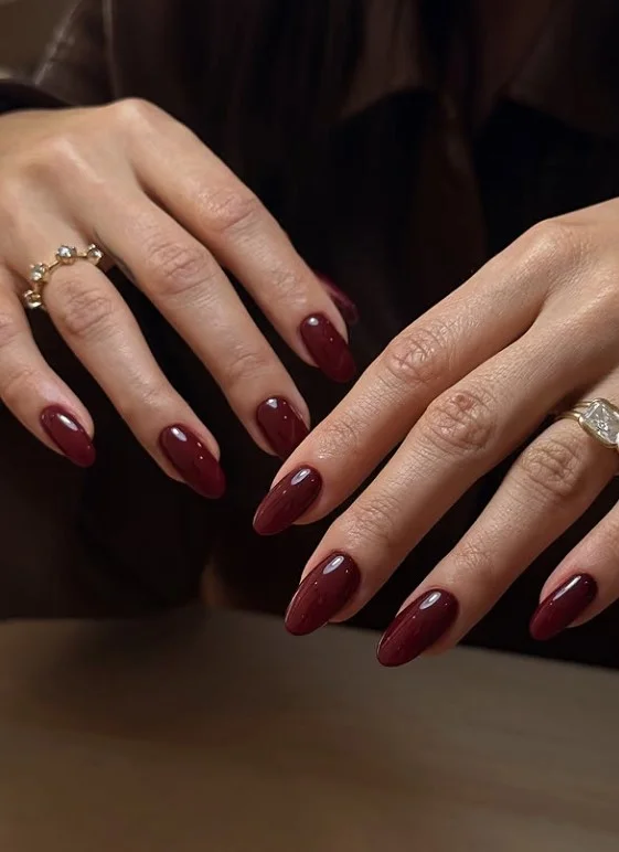 Cherry red nails on tan skin with a classic polished finish.