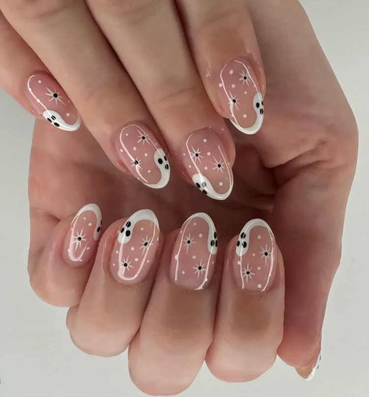 Cute ghost French tip Halloween nails with tiny white ghost nail art on a glossy nude base.