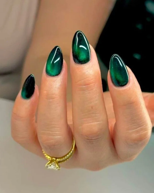 Emerald green manicure on tan skin with glossy almond nails.