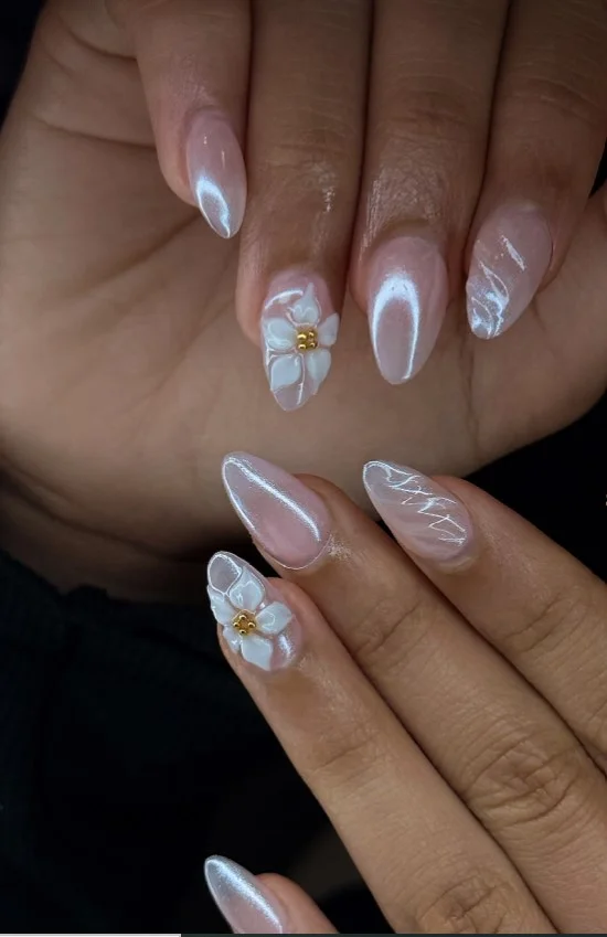 Glazed pearl chrome nails featuring metallic flower details with glossy finish.