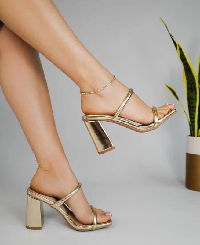 Gold heels styled with a navy dress for a wedding guest look