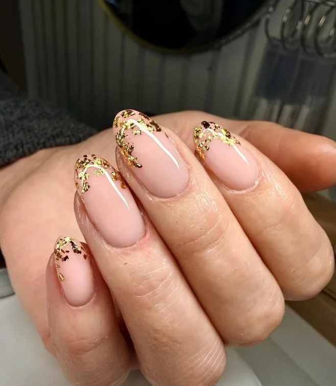 Nude nails with delicate gold leaf accents for elegant fall nail art.