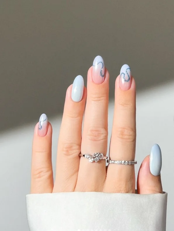 Icy blue manicure on pale skin for a cool winter nail look