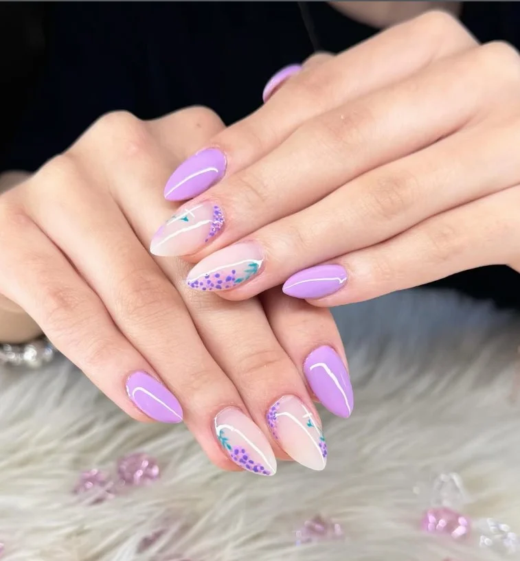 Lavender floral acrylic nails with delicate purple flowers on glossy nude base.
