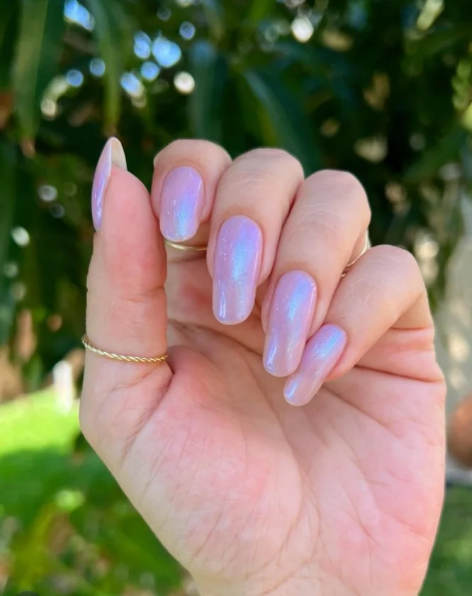 Lilac glazed donut nails with pearly chrome finish on glossy almond-shaped purple nails.