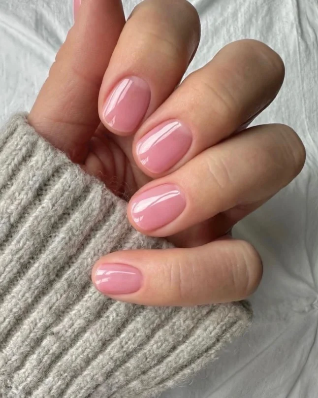 Lip gloss pink short nails with a glossy translucent finish on natural-looking press-ons.