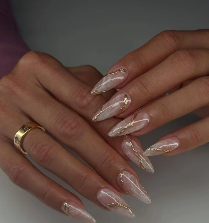 Marble acrylic nails with soft white swirls and elegant gold vein details.