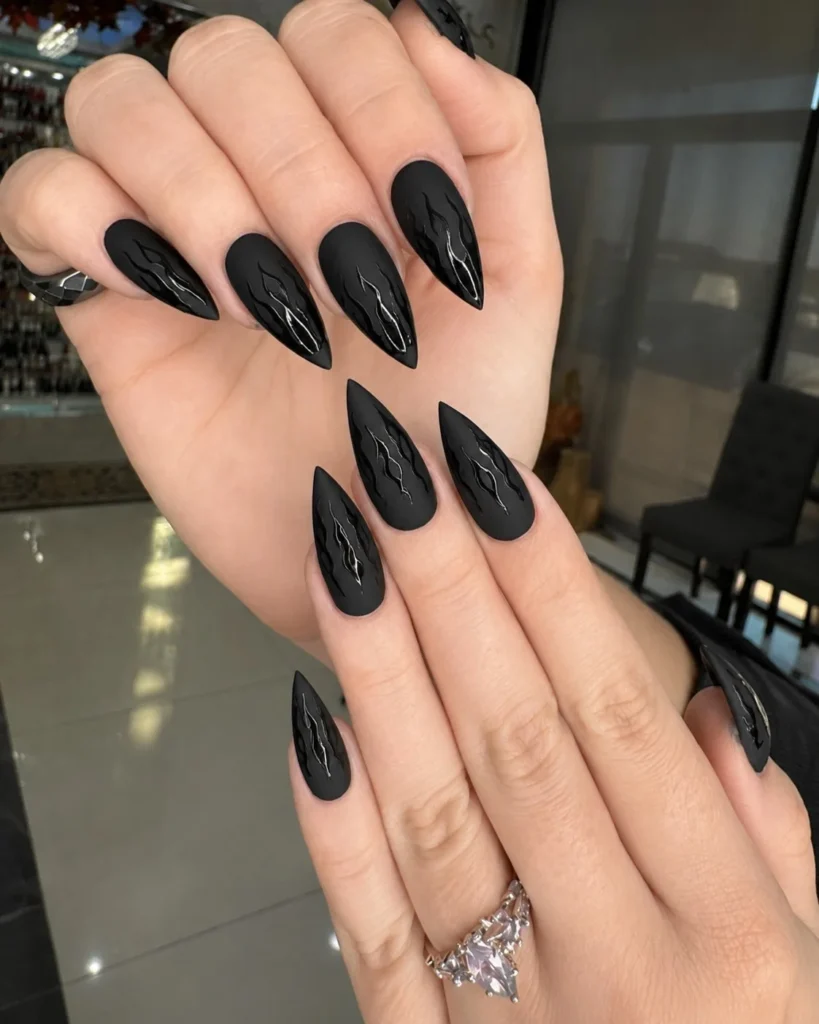 Matte black Halloween nails with glossy black flame nail art.