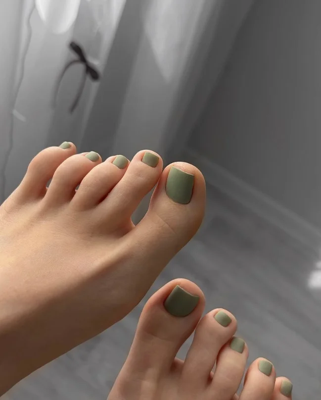 Matte olive green toe nails creating a modern earthy fall pedicure design.