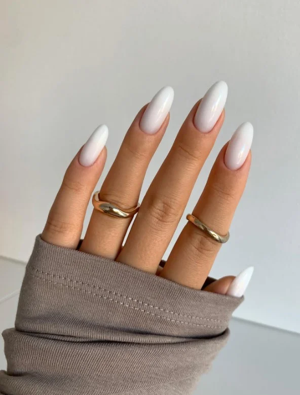 Milky white acrylic nails with glossy almond-shaped manicure and creamy white finish.
