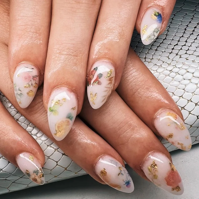 Milky white milk bath nails with real dried flower nail art and glossy top coat.