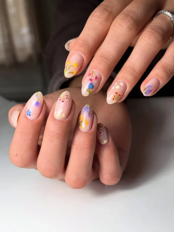 Pastel wildflower garden nail art with colorful floral details on almond nails.