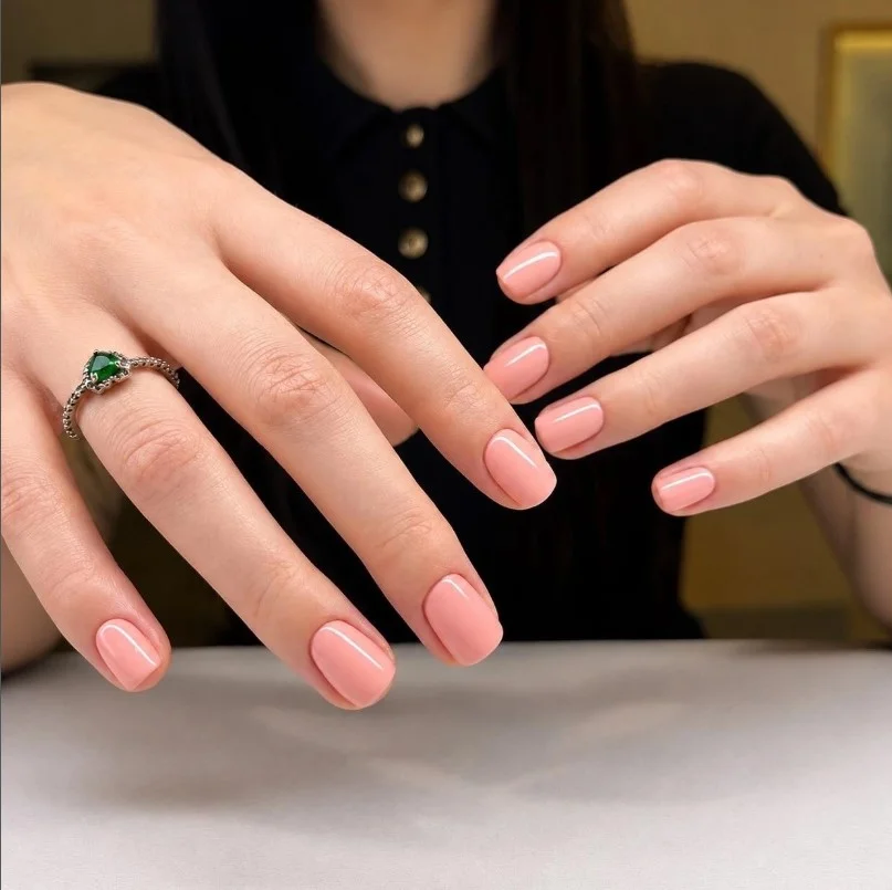 Peach nude nail polish on pale skin for a natural everyday look