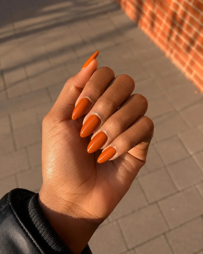 Pumpkin spice glazed nails with warm orange shimmer and glossy glazed finish.