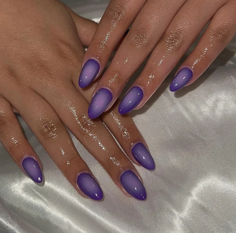 Purple aura glow nail designs with blended lilac and violet gradient effect.