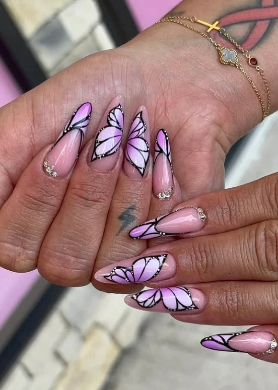 Purple butterfly accent nails with delicate butterfly art on glossy lavender polish.