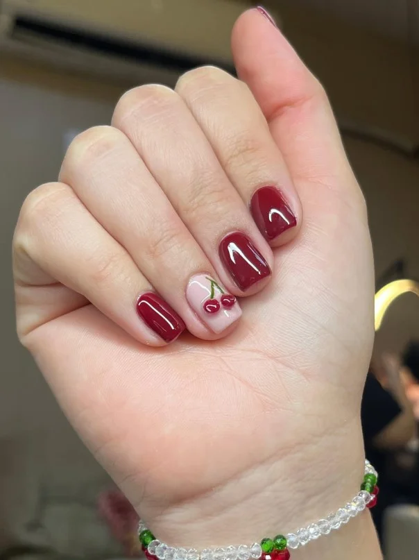 Short cherry nail designs with tiny cherry accents on nude base.