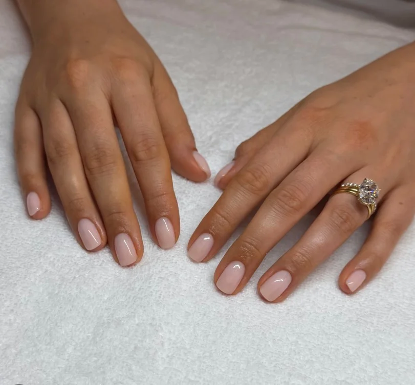 Short strawberry milk nails featuring creamy pastel pink glossy polish.
