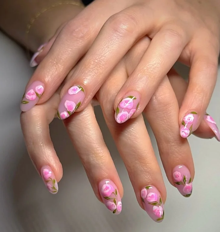 Soft pink rose nail designs with delicate floral details on glossy almond nails.