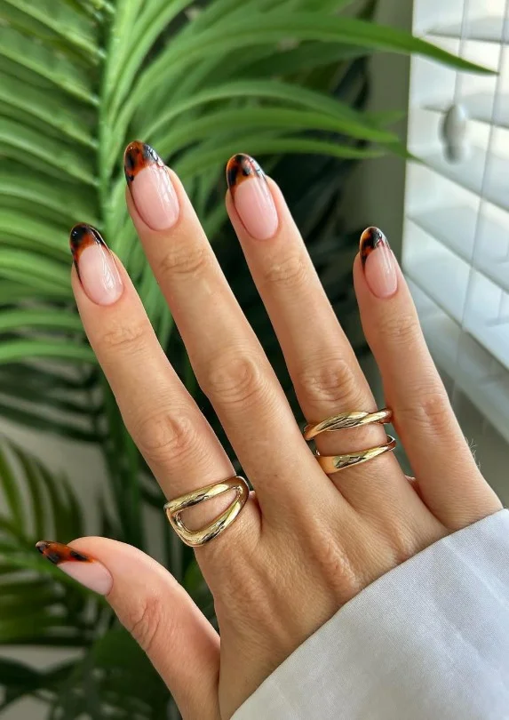Tortoiseshell French tip nails with warm amber and brown glossy finish.