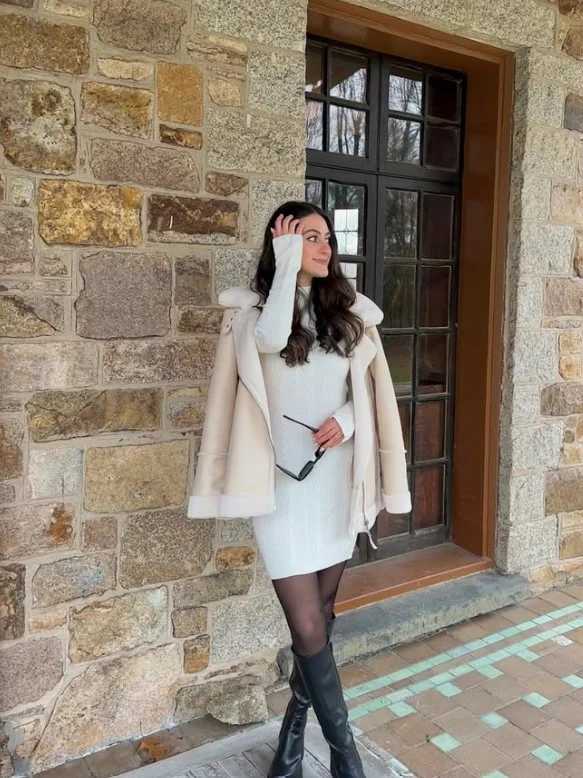 Sweater dress styled with black knee-high boots for winter