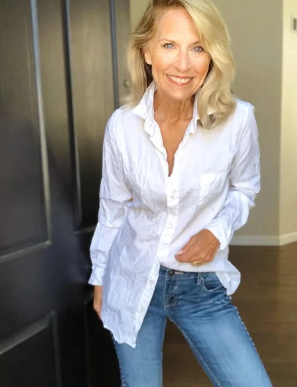 Woman wearing high waisted jeans with an oversized boyfriend shirt and loafers