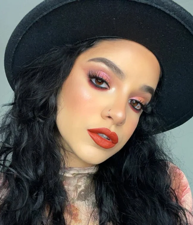 Brick red lipstick creating a sophisticated fall makeup look.