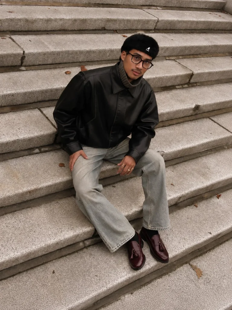 Burgundy penny loafers styled with grey dress pants and a tailored jacket.