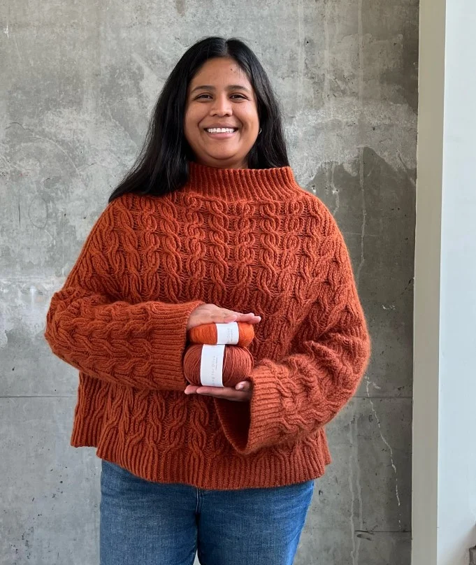 Burnt orange knit sweater paired with dark denim for fall fashion.