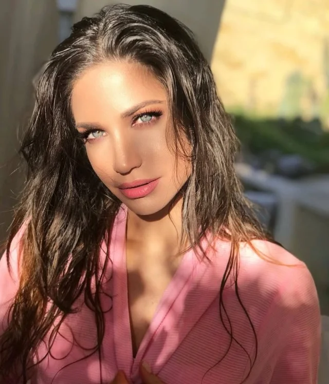 Coral lipstick brightening fair skin with fresh summer makeup.