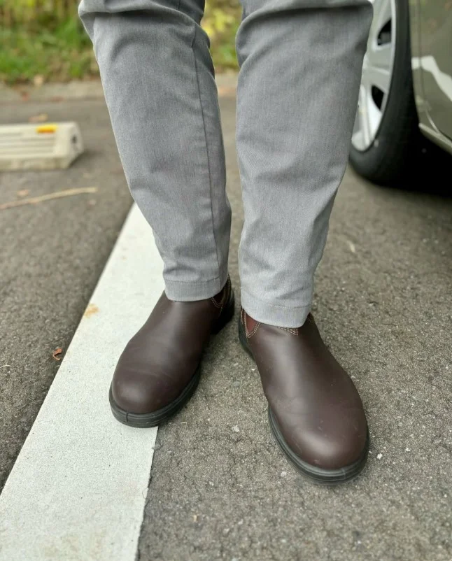 Dark brown leather Derby shoes styled with medium grey trousers and a white shirt.