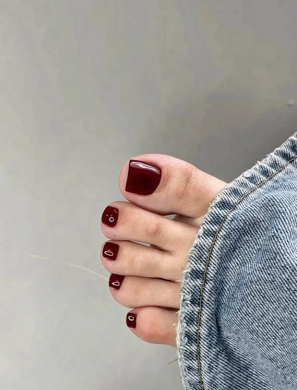 Deep burgundy toenails with a glossy evening finish