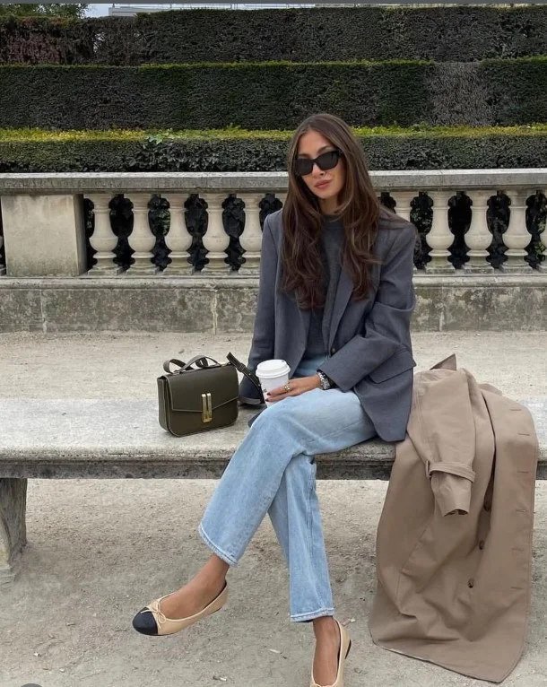 Woman wearing light-wash jeans with a gray blazer and white tee