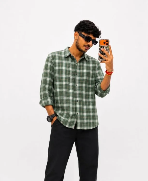 Green flannel shirt styled with black jeans and boots