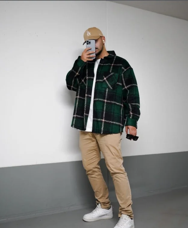 Green flannel worn open over a white T-shirt with jeans
