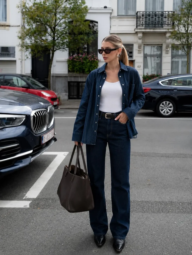 Open denim button down shirt over a white tank and jeans