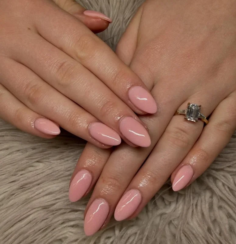 Soft peach nail polish adding warmth to pale hands.