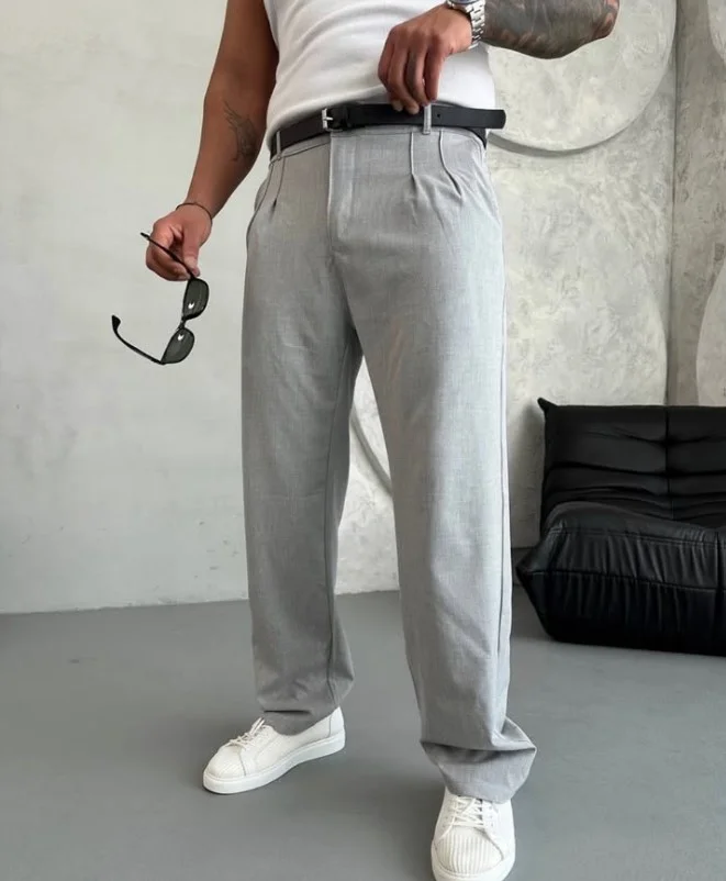 White leather sneakers worn with slim-fit grey chinos and a casual T-shirt.