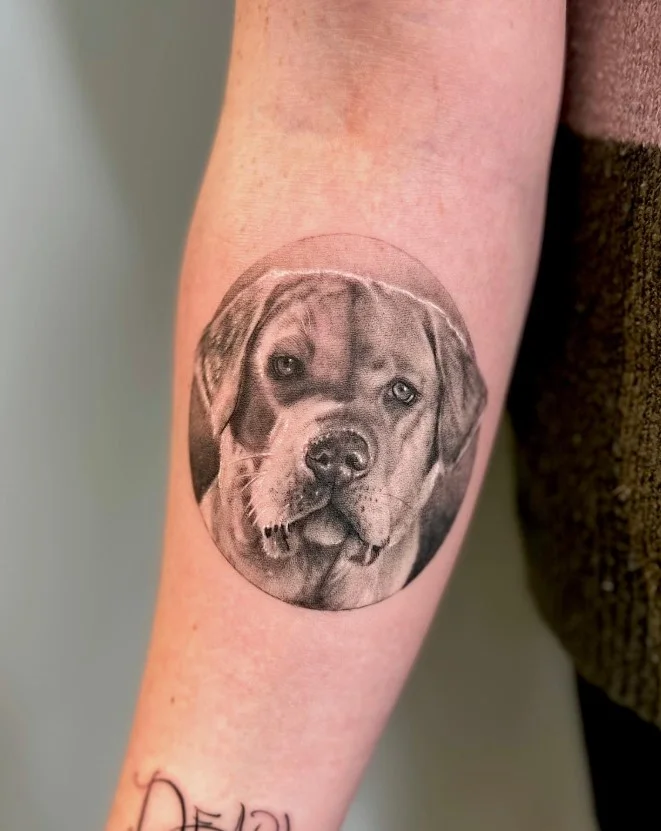 Detailed animal portrait forearm tattoo with realistic shading and defined facial features