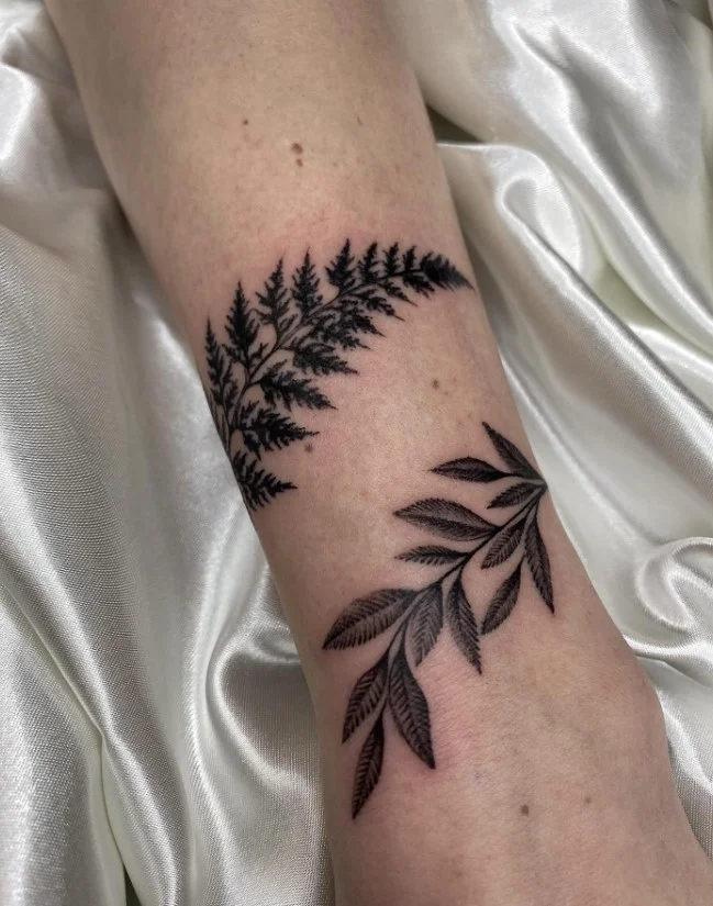 Long botanical branch with leaves curving naturally around a woman's forearm