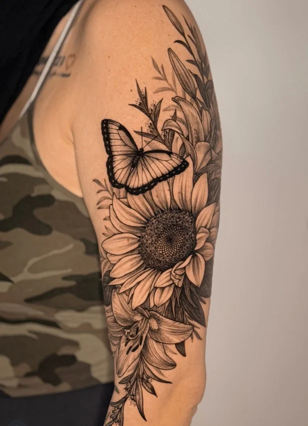 Butterfly and flower upper arm tattoo combining nature-inspired elements