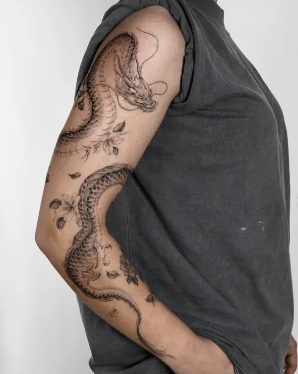 Dragon wrapped around arm tattoo with a detailed coiled dragon design