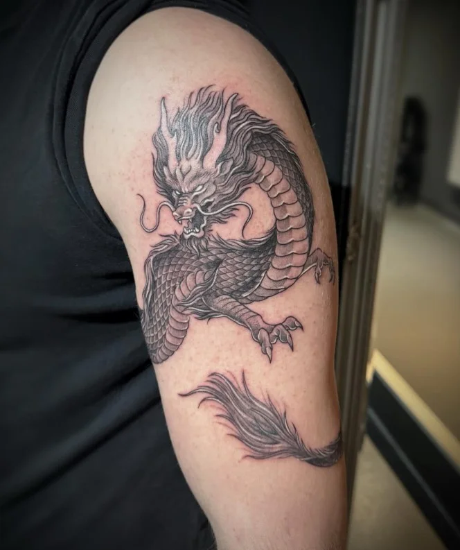 Dragon wrapped around bicep tattoo with a detailed coiled dragon design