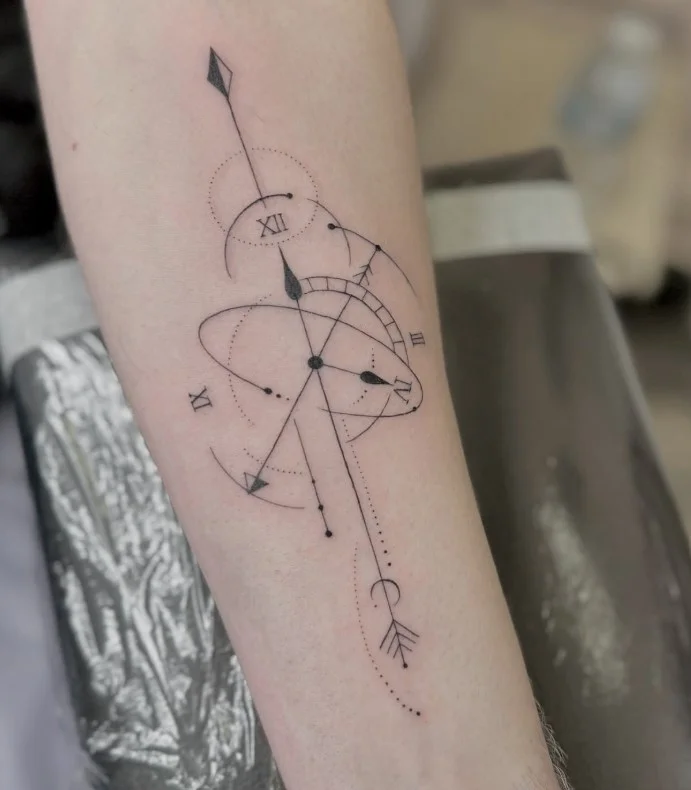 Fine-line compass tattoo with clear directional details on the inner forearm