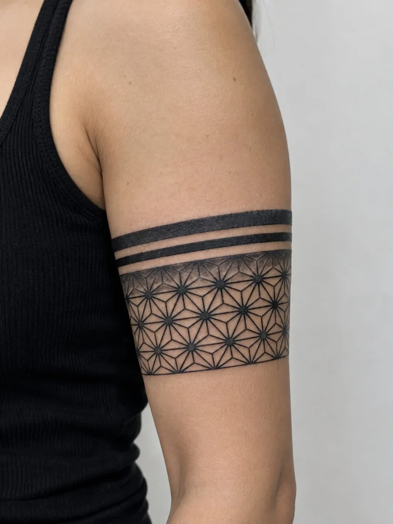 Geometric linework bicep wrap tattoo with circles, angles, and repeating patterns
