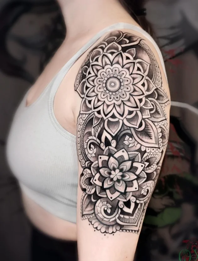 Mandala upper arm tattoo with symmetrical detailed black ink design