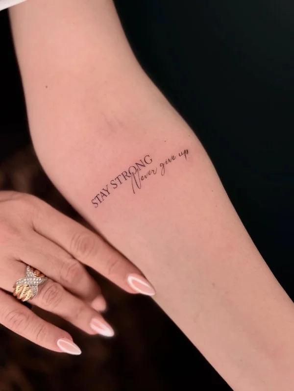 Meaningful handwritten word tattoo running along the inner forearm