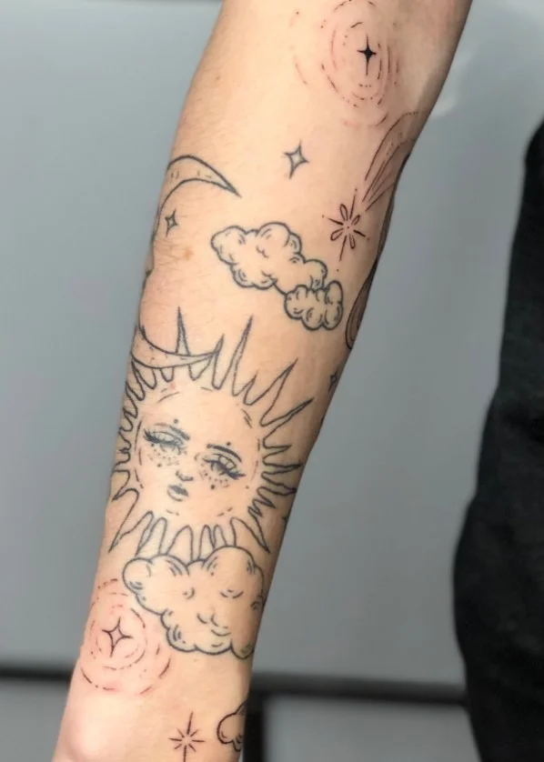 Moon, sun and stars wrap around arm tattoo with celestial symbols and open space